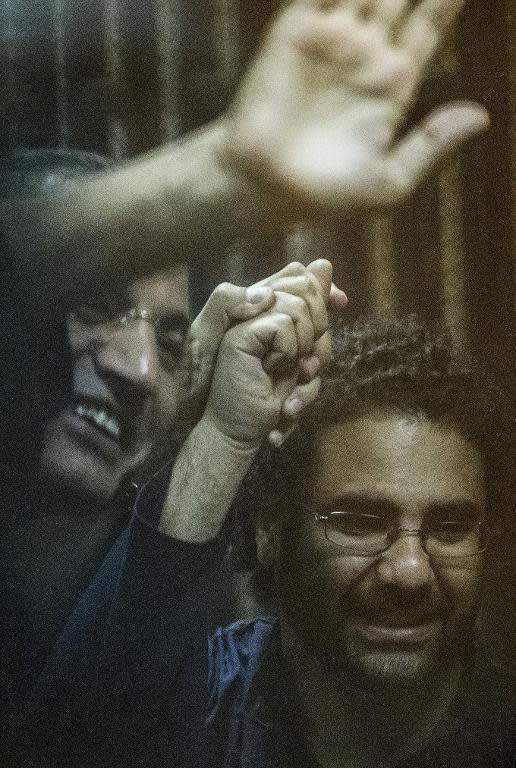 Egyptian activist and blogger Alaa Abdel Fattah (R) and Islamist Essam Sultan attend their trial for insulting the judiciary alongside 25 other defendants including ousted Egyptian president Mohamed Morsi, in Cairo on May 23, 2015
