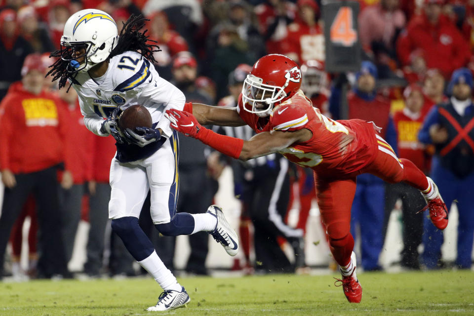 Los Angeles Chargers wide receiver Travis Benjamin (12) runs away from a tackle attempt by Kansas City Chiefs cornerback Kendall Fuller (23) during the second half of an NFL football game in Kansas City, Mo., Thursday, Dec. 13, 2018. The Los Angeles Chargers won 29-28. (AP Photo/Charlie Riedel)