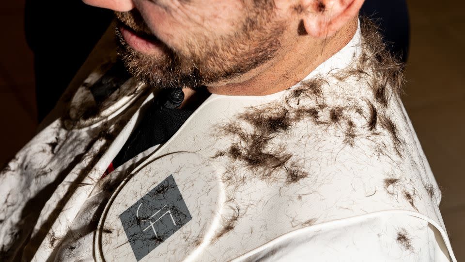 Hair clippings sit on the shoulders of tennis player Austin Krajicek while getting his hair cut by Julien Farel in Arthur Ashe Stadium in New York on August 30. - Will Lanzoni/CNN