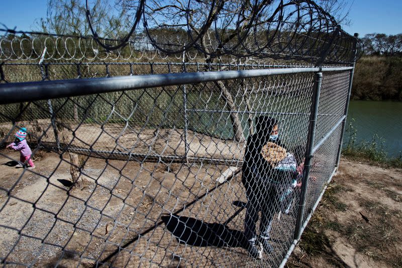 FILE PHOTO: Blanca Urrutia, a Honduran migrant who is seeking asylum in the U.S., is pictured with their children at a migrant encampment in Matamoros