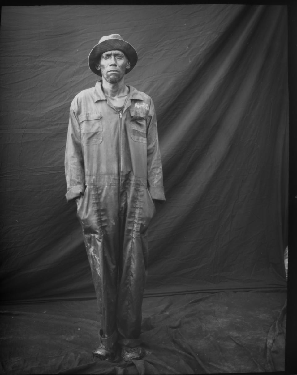 Former oil worker David Ortiz poses for a portrait in one of his old PDVSA uniforms, which he uses to work as a fisherman, after a day's work on oil-contaminated Lake Maracaibo in Cabimas, Venezuela, July 12, 2019. (AP Photo/Rodrigo Abd)