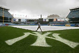 Yankee Stadium electrician Tito Baez walks across the infield while shutting down the stadium power after Game 4 of the ALDS was called because of rain Saturday. Julie Jacobson | Associated Press