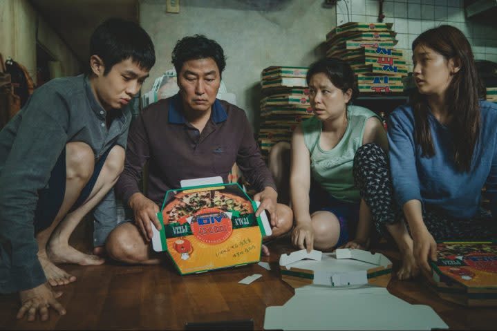 Kim Ki-taek with his family gathered together on the floor.