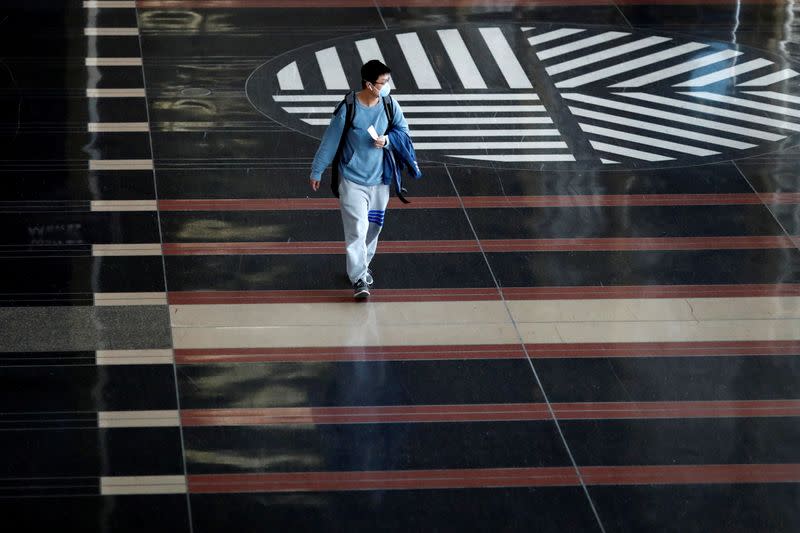 A man wearing a face mask walks along the main terminal of Ronald Reagan Washington National Airport as the World Health Organization said for the first time on Wednesday that it now sees the coronavirus outbreak as a pandemic, in Washington, U.S.