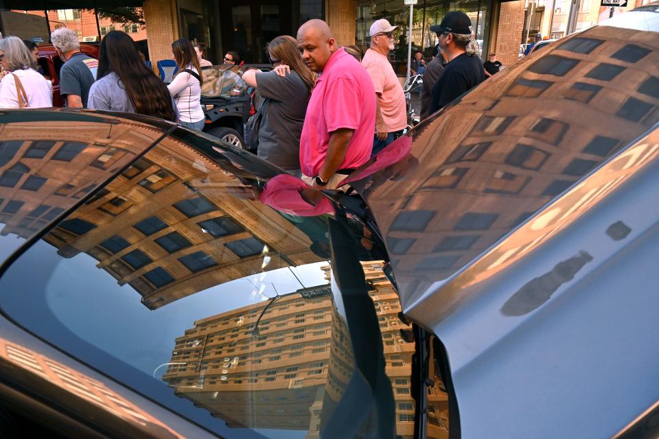 The buildings of downtown Abilene are reflected in the hood and windshield of a late-model Ford Mustang on Cypress Street Thursday.