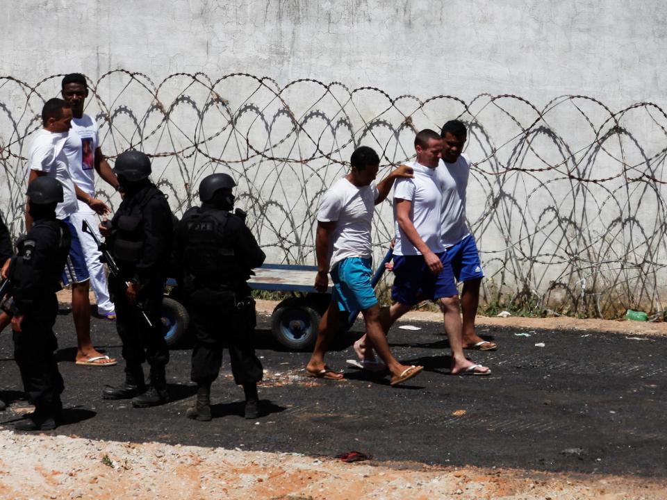 Inmates next to riot policemen during an uprising at Alcacuz prison (REUTERS)