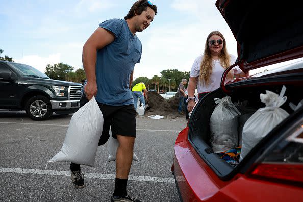 Chris Tate (left) and Heather Tallmadge place sandbags in their car at Helen Howarth Park as they prepare for the possible arrival of Hurricane Ian on September 26, 2022, in St. Petersburg, Florida.