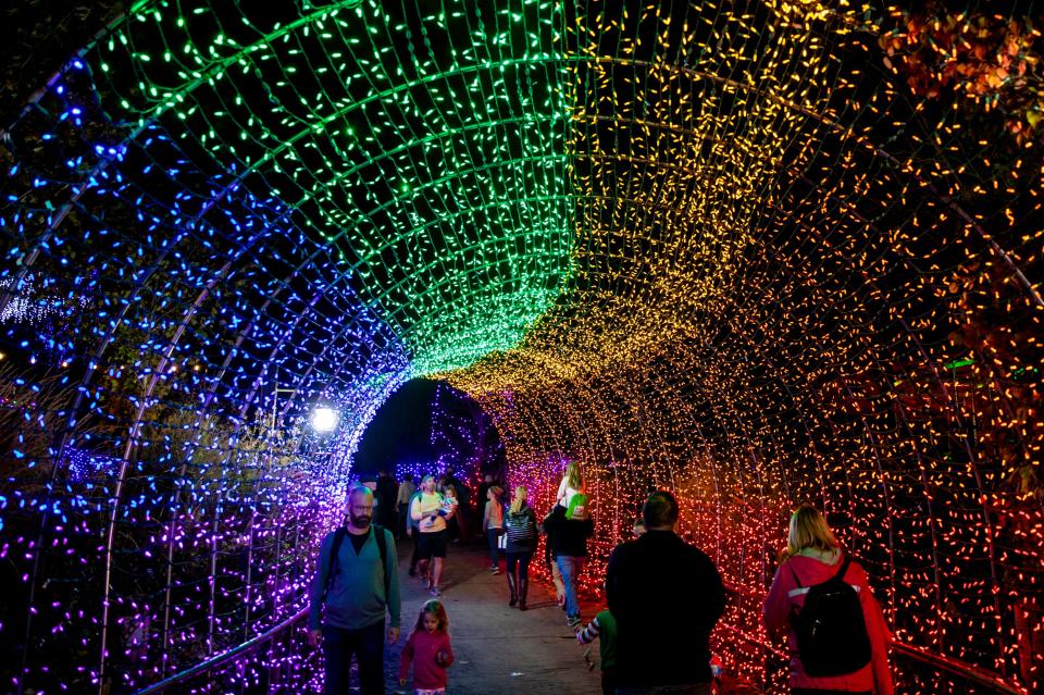 Visitors walk through the rainbow tunnel at the PNC Festival of Lights at the Cincinnati Zoo and Botanical Garden in 2021.