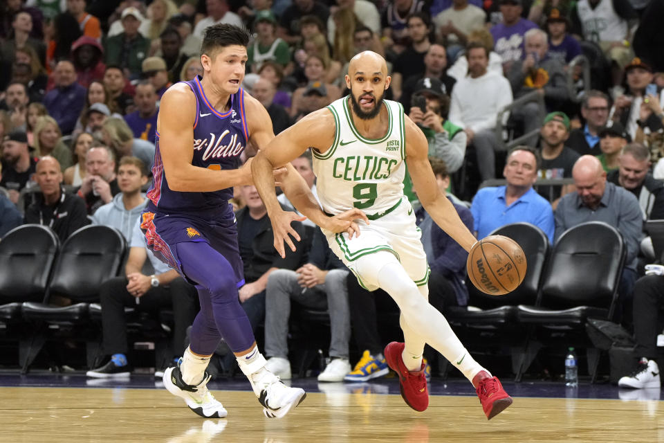 Boston Celtics guard Derrick White (9) drives past Phoenix Suns guard Grayson Allen, left, during the first half of an NBA basketball game, Saturday, March 9, 2024, in Phoenix. (AP Photo/Rick Scuteri)