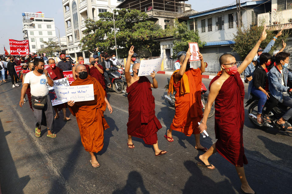Buddhist monks flash a three-fingered salute of defiance in Mandalay, Myanmar on Monday, Feb. 8, 2021. A protest against Myanmar's one-week-old military government swelled rapidly Monday morning as opposition to the coup grew increasingly bold. (AP Photo)