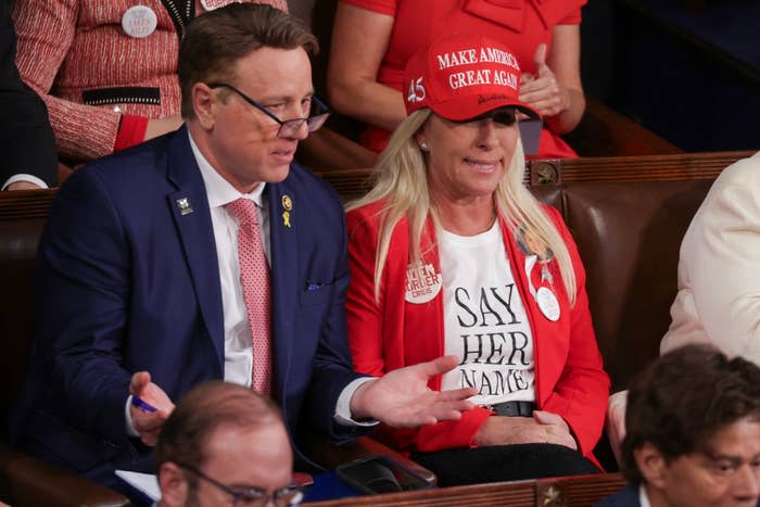 MTG wearing a MAGA hat seated at the SOTU