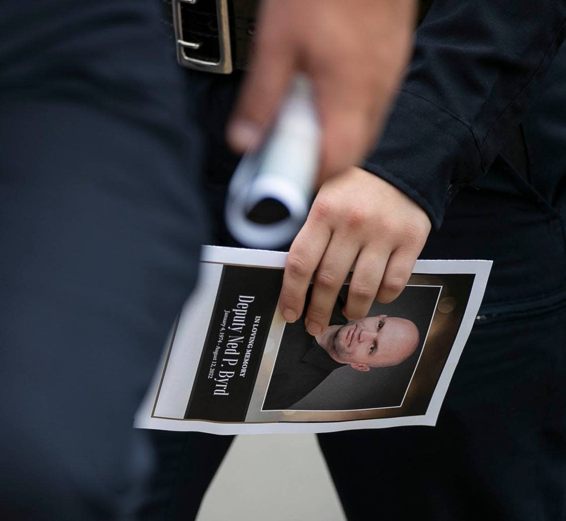 Law enforcement officers carry funeral programs with a photograph of Wake County Deputy Ned Byrd on them as they leave his service at Providence Baptist Church on Friday, August 19, 2022 in Raleigh, N.C.