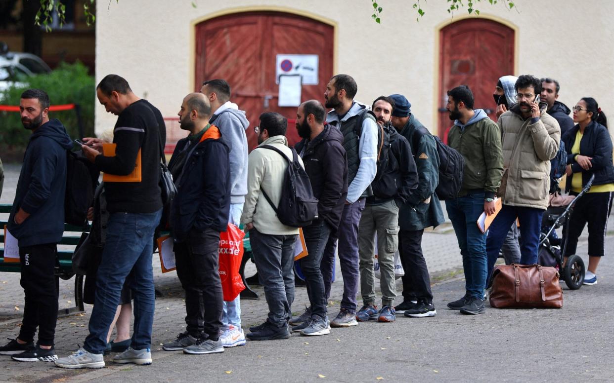 Migrants queue in a waiting area in Berlin