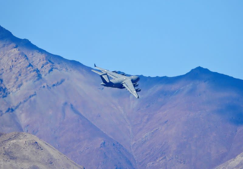 An Indian Air Force's (IAF) C-17 Globemaster transport plane flies over a mountain range in Leh