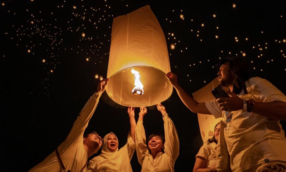 Los devotos budistas y los turistas lanzan una linterna al aire por la noche