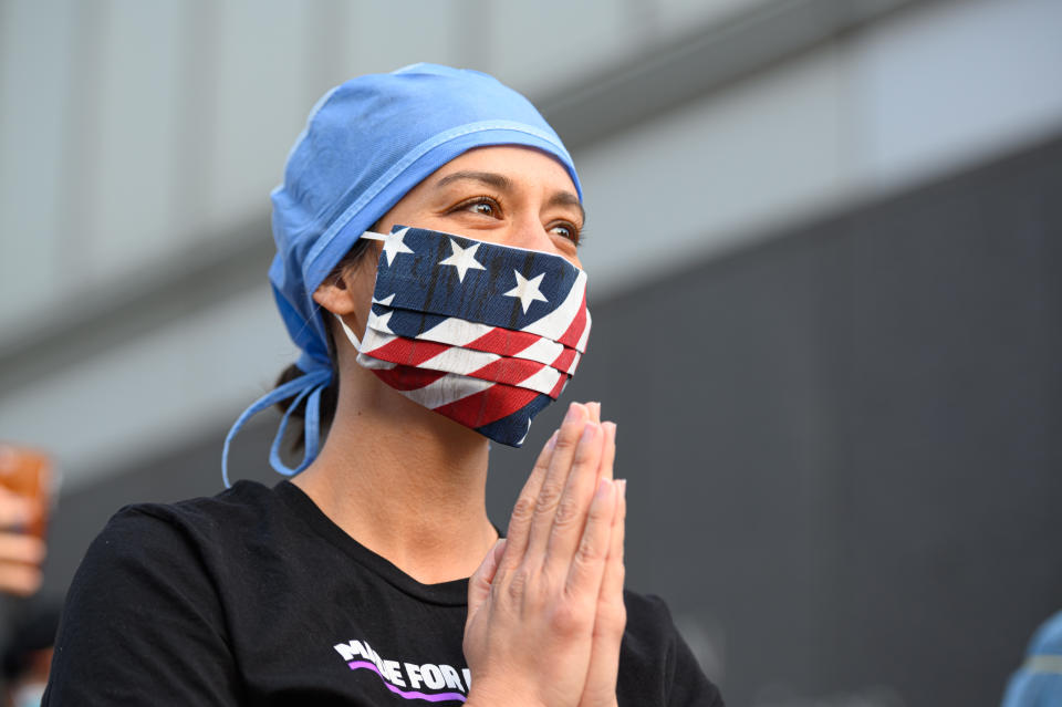 NEW YORK, NEW YORK - APRIL 28: A medical worker stands outside NYU Langone Health hospital as people applaud to show their gratitude to medical staff and essential workers on the front lines of the coronavirus pandemic on April 28, 2020 in New York City. COVID-19 has spread to most countries around the world, claiming over 217,000 lives with over 3.1 million infections reported. (Photo by Noam Galai/Getty Images)