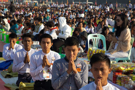 People attend for an alms offering ceremony organised by the Thailand's Dhammakaya Foundation at the Chanmyathazi airport in Mandalay, Myanmar, January 21, 2018. REUTERS/Ann Wang