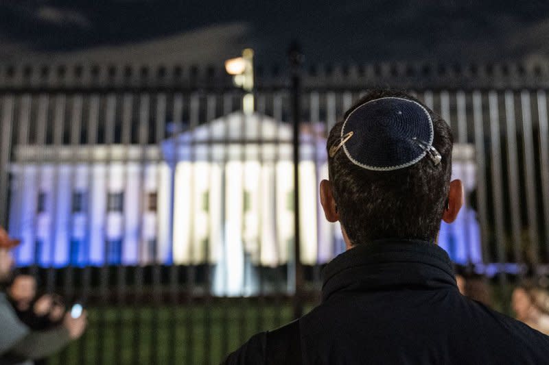 People gather outside of the The White House as it is illuminated in blue and white, the colors of the Israeli flag, in support of Israel on Monday in Washington, D.C. President Joe Biden said Wednesday 22 Americans were among those killed in Israel. Photo by Leigh Vogel/UPI