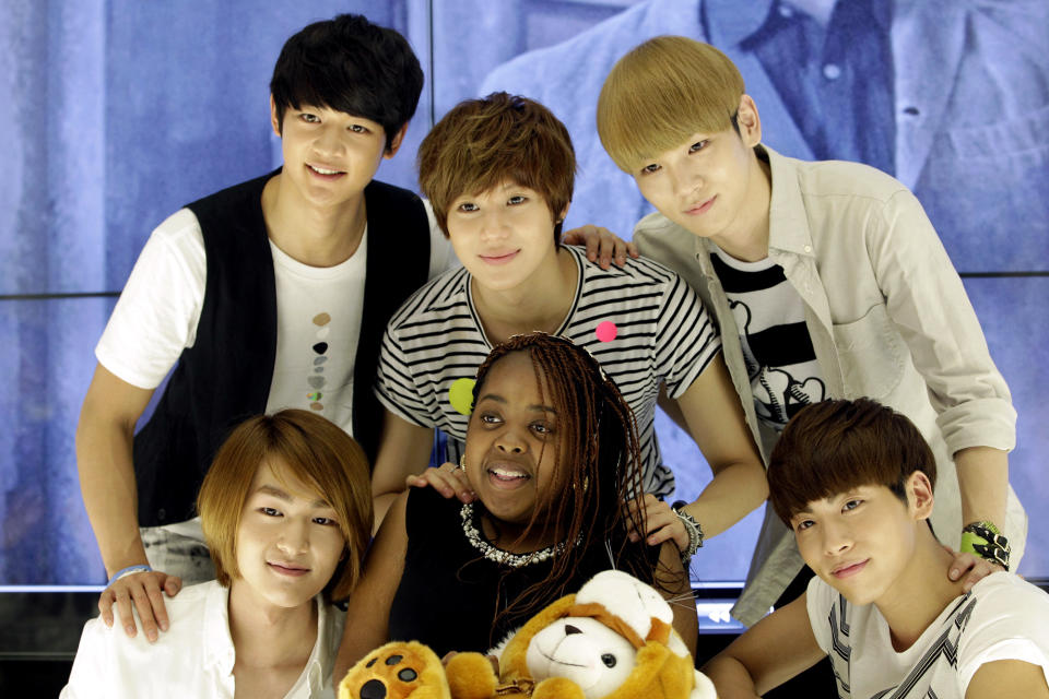 Donika Sterling from New York, center, poses for the media with members of South Korean pop group SHINee during their meeting in Seoul, South Korea, Wednesday, June 20, 2012. The 15 year-old American K-pop fan, who is suffering a disease that gradually causes loss of muscle tissue and slows down parts of the body, met and sang with the boy band she idolizes. (AP Photo/Lee Jin-man)