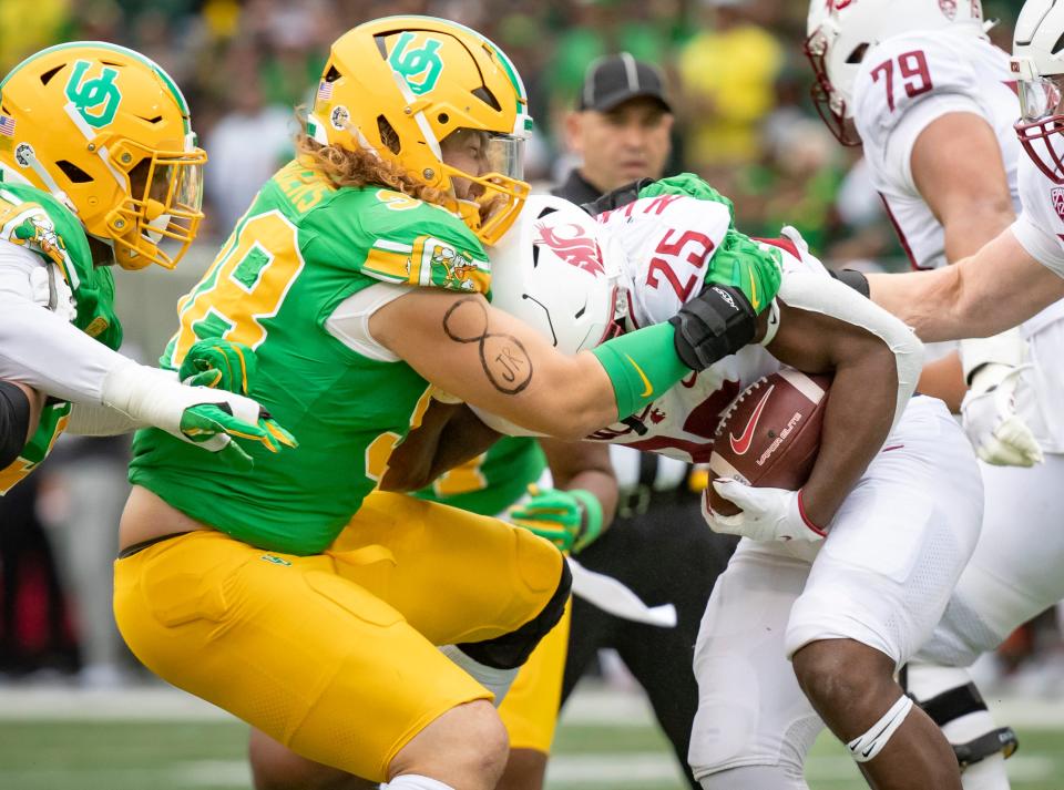 Oregon defensive lineman Casey Rogers stops Washington State running back Nakia Watson as the No. 9 Oregon Ducks host Washington State on Oct. 21 at Autzen Stadium in Eugene.