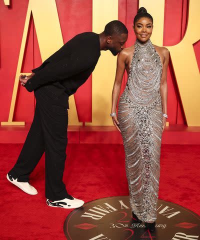 <p>Christopher Polk/Variety via Getty</p> Dwyane Wade kisses Gabrielle Union's shoulder at Vanity Fair Oscars Party 2024