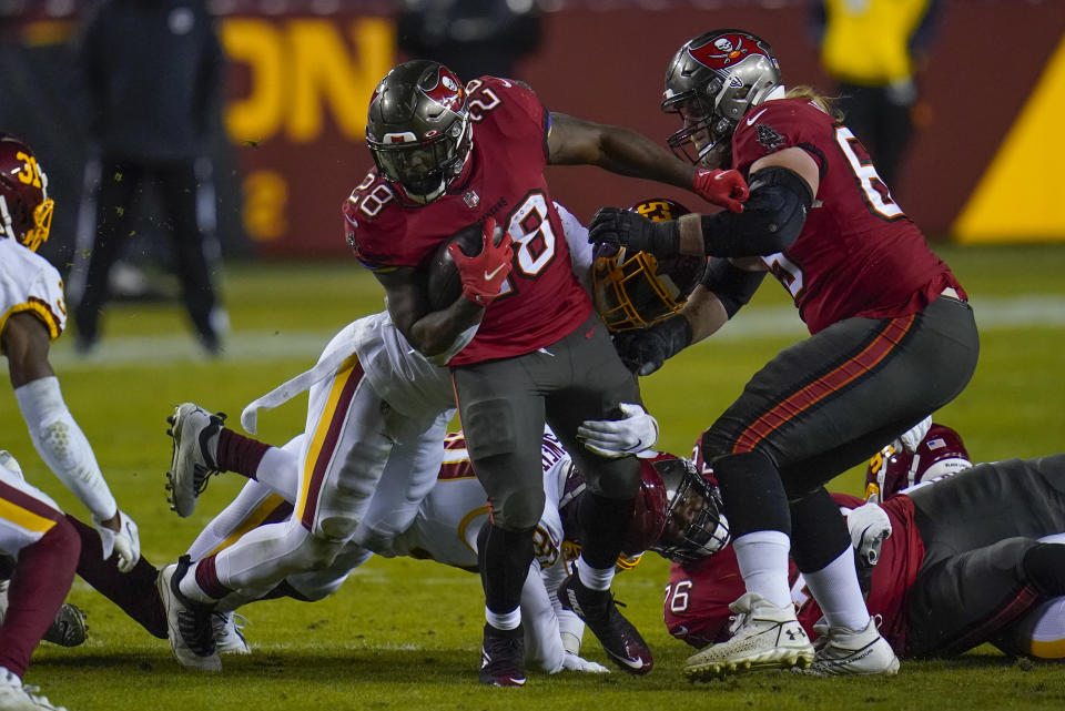 Tampa Bay Buccaneers running back Leonard Fournette (28) is taken down by Washington Football Team middle linebacker Jon Bostic (53) during the first half of an NFL wild-card playoff football game, Saturday, Jan. 9, 2021, in Landover, Md. (AP Photo/Julio Cortez)