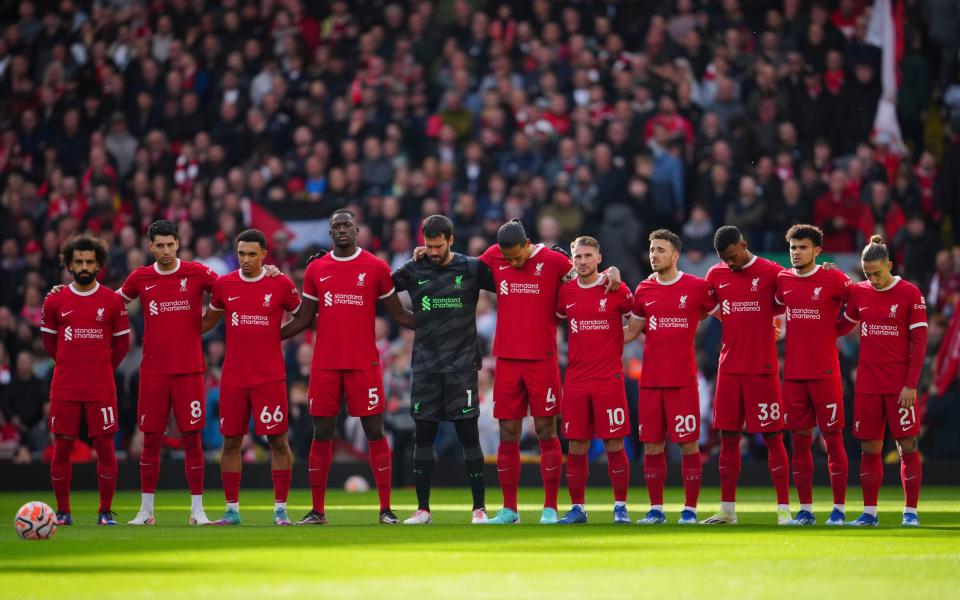 Liverpool players stand during a moment of silence for the victims of the Israeli-Hamas war