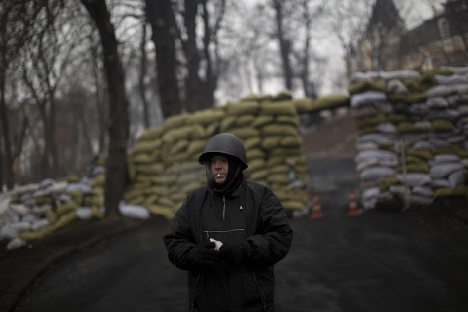 An opposition supporter stands guard a barricade in a street near to Kiev's Independence Square, the epicenter of the country's current unrest, Ukraine, Friday, Feb. 7, 2014. Ukrainian protesters lambasted parliament on Thursday for its lack of action, and a senior U.S. diplomat arrived in Kiev to try to help find a resolution to the country's grinding political crisis. Assistant Secretary of State Victoria Nuland met separately with President Viktor Yanukovych and with opposition leaders during her two-day stay in the Ukrainian capital. (AP Photo/Emilio Morenatti)