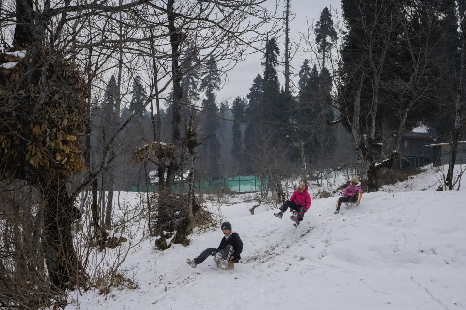 Kashmiri village boys slide down a snowy slope on sledges in Drang village northwest of Srinagar, Indian controlled Kashmir Friday, Dec. 22, 2023. This is the time of "Chillai Kalan," also called "The Great Winter," a Kashmiri phrase which defines the harshest 40 days of cold in disputed Kashmir that commence in late December and extend into January and early February. (AP Photo/Dar Yasin)