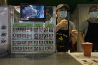 A staff member gestures behind the counter with a board showing informations by sign languages at Dignity Kitchen in Hong Kong on Nov. 17, 2020. Located smack in the middle of Hong Kong's bustling Mong Kok neighborhood, Dignity Kitchen offers an array of mouthwatering Singaporean fare. But what sets Dignity Kitchen apart from other restaurants in the city is that it is a social enterprise, almost entirely staffed by employees with physical or mental disabilities. (AP Photo/Vincent Yu)