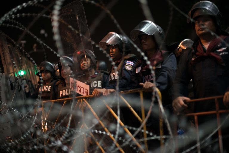 Riot police secure an area outside Government House as Thai opposition protesters attend an anti-government rally in Bangkok on November 11, 2013