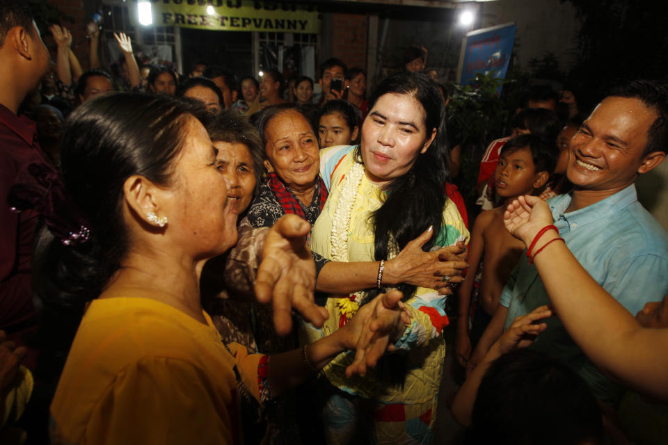 A prominent leader of Cambodia's land rights activist Tep Vanny, center, is celebrated by her villagers upon the arrival at her home in Boeung Kak, in Phnom Penh, Cambodia, Monday, Aug. 20, 2018. A prominent leader of Cambodia's land rights movement and three women activists who were sent to prison with her were freed Monday under a royal pardon. (AP Photo/Heng Sinith)