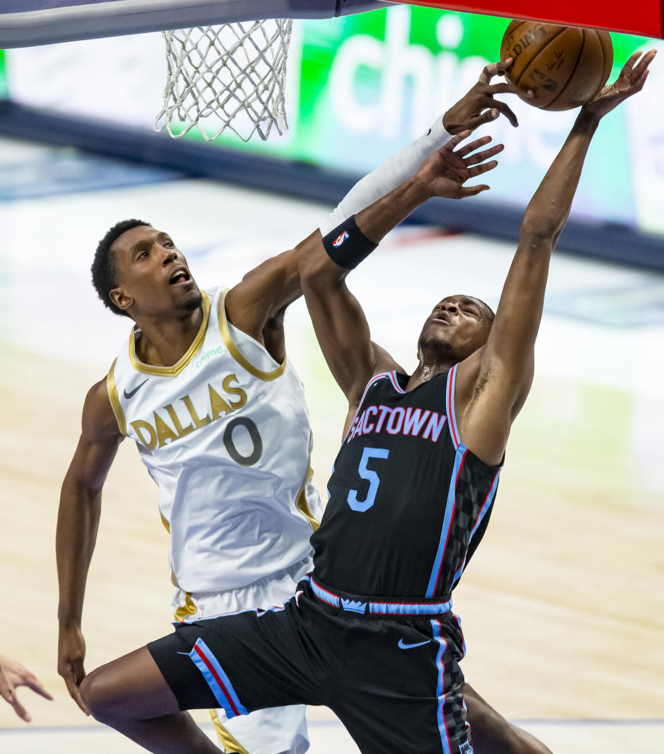 Dallas Mavericks guard Josh Richardson (0) fouls Sacramento Kings guard De'Aaron Fox (5) during the second half of a NBA basketball game, Sunday, April 18, 2021, in Dallas. (AP Photo/Brandon Wade)