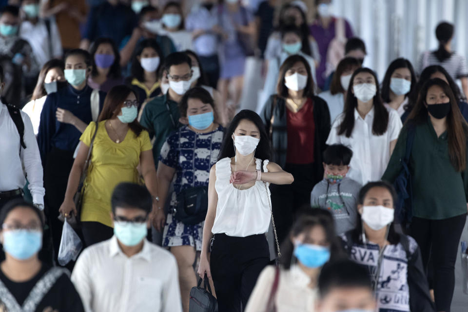 Office workers wearing face masks to help curb the spread of the coronavirus head to worlplaces in Bangkok, Thailand, Thursday, May 21, 2020. Thai health officials say scientists in Thailand have had promising results in testing a COVID-19 vaccine candidate on mice, and will begin testing it on monkeys next week.(AP Photo/Sakchai Lalit)