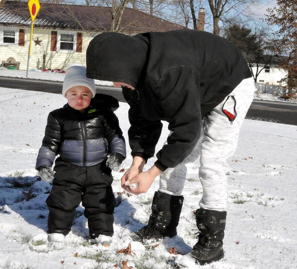 Luke Myers of Wooster shows his 21-month-old son, Noah, how to make a snowball. The National Weather Service predicts 4-7 inches of snowfall by Friday evening.