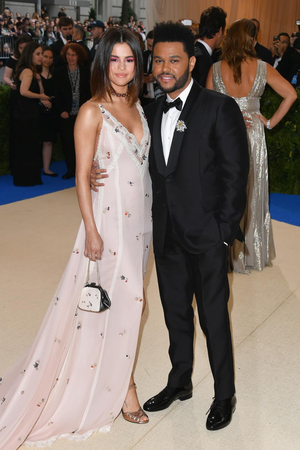 <h1 class="title">Selena Gomez in Coach and Tiffany jewelry and The Weeknd in a Valentino tuxedo</h1><cite class="credit">Photo: Getty Images</cite>