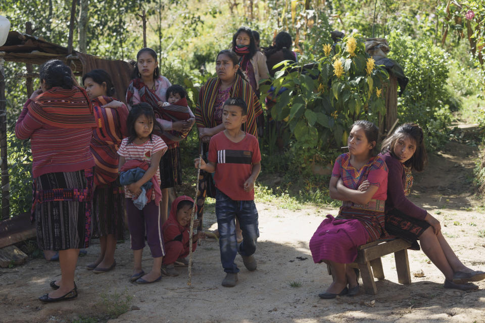 Neighbors gather outside the family home of Salvador Mateo Tiniguar, in Chepol, in the western highlands of Guatemala, Saturday, Dec. 11, 2021. Salvador Mateo Tiniguar, who was migrating to the United States, was traveling on the truck that crashed in Mexico that killed 55 migrants. His family does not know what happened to him as they wait for information from Mexican authorities who have released a list of seven seriously injured unidentified people. (AP Photo/Moises Castillo)