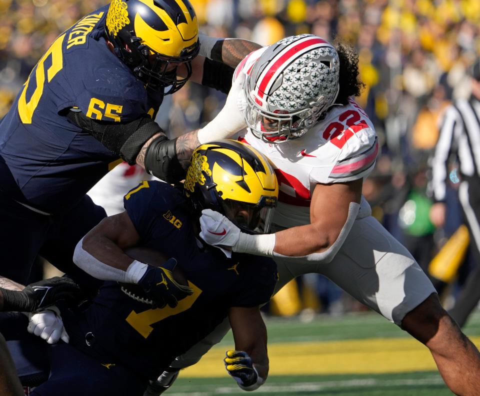 Ohio State linebacker Steele Chambers (22) brings down Michigan running back Donovan Edwards (7) on Nov. 25.