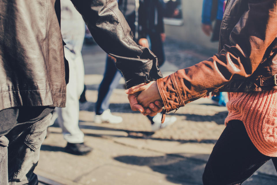 two people holding hands in public