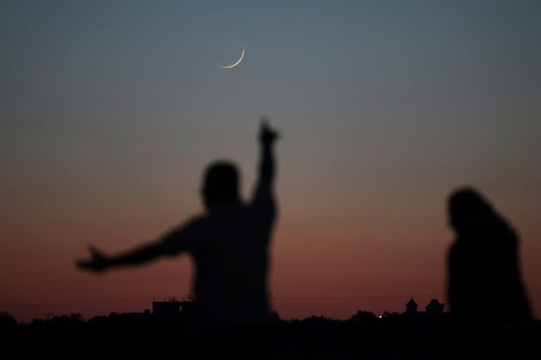 A Palestinian man points towards the crescent moon in Khan Yunis in the southern Gaza Strip on May 16, 2018, a day before the start of the Muslim holy month of Ramadan