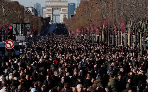 Fans gather on the Champs Elysees Avenue during a 'popular tribute' to the late French singer and actor Johnny Hallyday in Paris, France, December 9, 2017 - Credit: BENOIT TESSIER/REUTERS