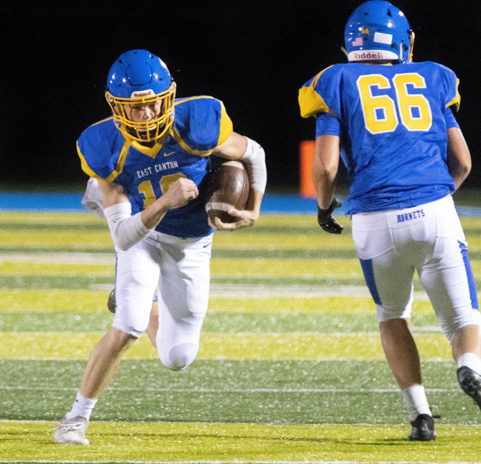 East Canton's Toby Schrader runs next to the blocking of teammate Kyle Peterson (66). Peterson was a second team All-Inter-Valley Conference North Division selection for the Hornets last season.