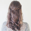 <p>Take one of the braids and pull it around the back of your head, securing in place with a hair grip. </p>