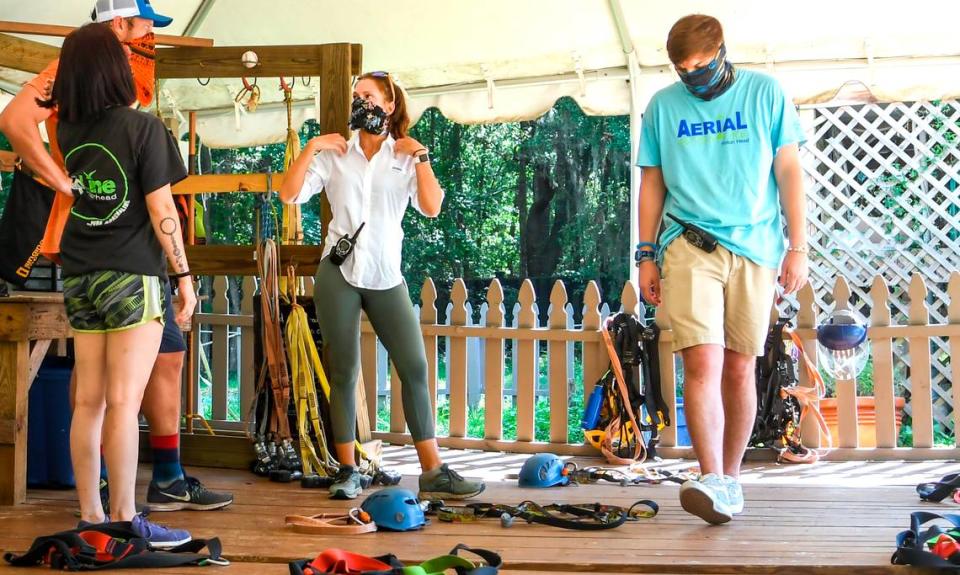 Olivia Panozzo, center, director of operations at ZipLine Hilton Head, goes over details on the harness system with employees on Tuesday, June 30, 2020 on Hilton Head Island. Before the Town off Hilton Head Island’s ordinance for mandatory face coverings, employees at the outdoor adventure company were wearing face coverings, kept customers six feet apart and wear plastic face shields when checking customers gear to reduce the spread of the coronavirus.