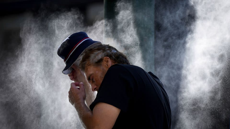 A man cools off at a temporary misting station deployed by the city in the Downtown Eastside due to a heat wave, in Vancouver, British Columbia, Aug. 16, 2023.  - Darryl Dyck/The Canadian Press/AP