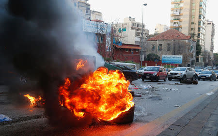 Cars pass near burning tires in Beirut, Lebanon January 29, 2018. REUTERS/Mohamed Azakir