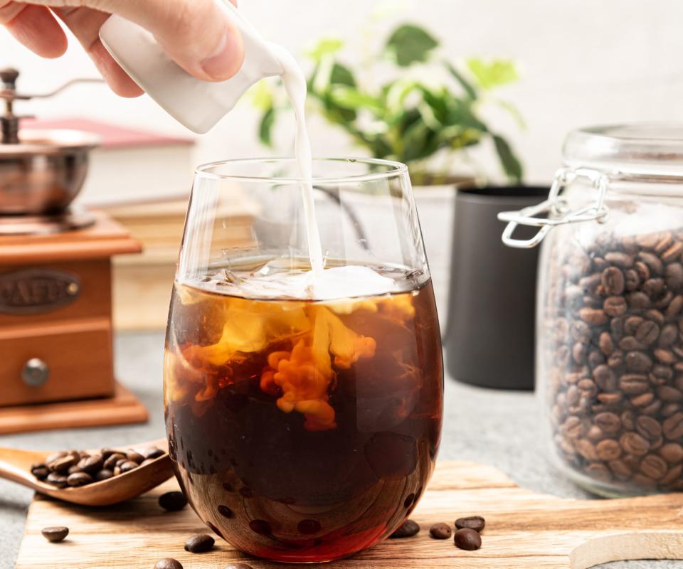 cold brew coffee on a countertop with milk being poured in