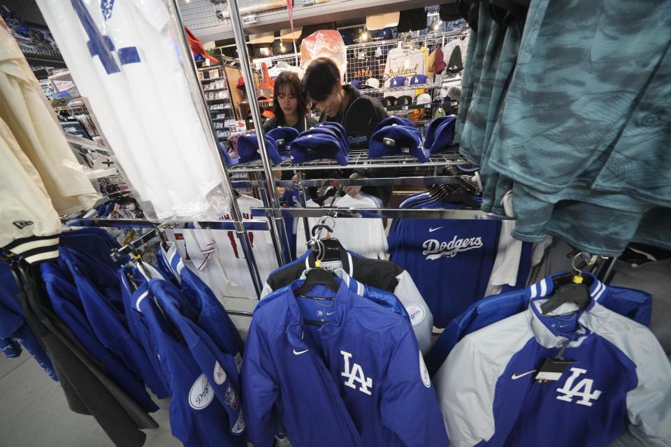 Customers shop around for goods related to Shohei Ohtani of the Los Angeles Dodgers at a sporting goods store, 