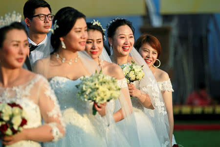 Chinese brides pose for photographs during the mass wedding ceremony for fifty Chinese couples in Colombo, Sri Lanka December 17, 2017. REUTERS/Dinuka Liyanawatte