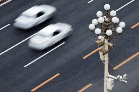 Cars drive on Chang'an Avenue near Tiananmen Square in Beijing